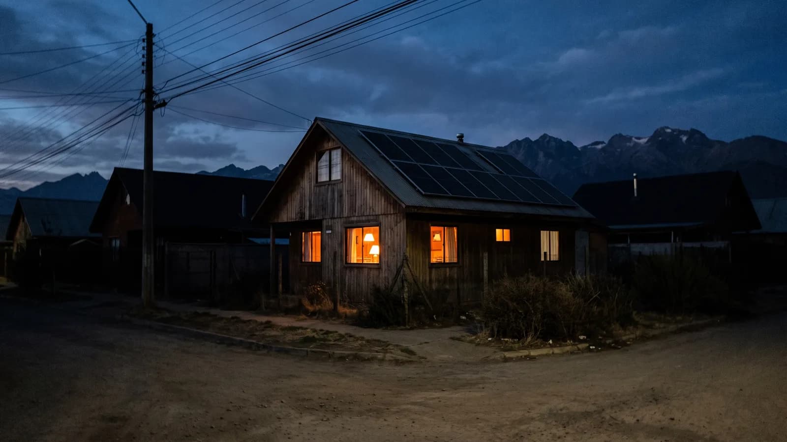Casa con paneles solares iluminada durante un corte de luz en el barrio